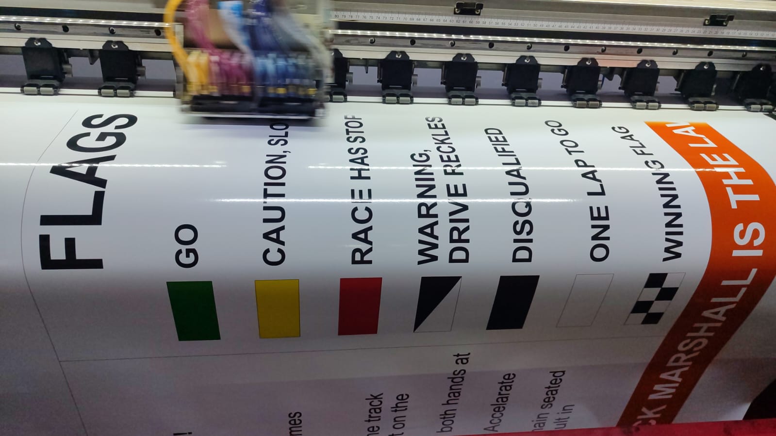Racing flags themed banner being printed on large format printer