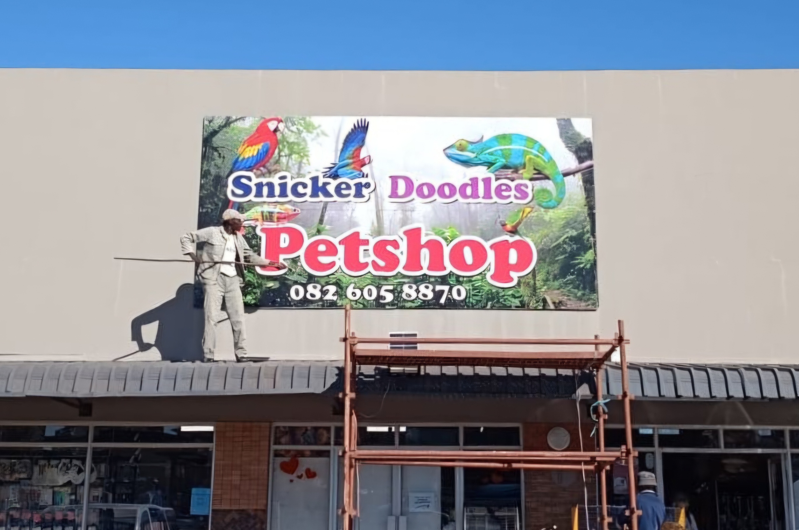 Snicker Doodles Pet Shop large building banner with parrot graphics on storefront